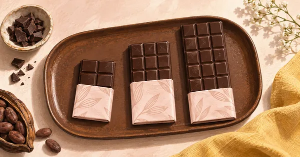 Illustration of three different-sized dark chocolate bars on a brown tray Illustration of three different-sized dark chocolate bars on a brown tray