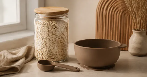 Illustration: fine dry oat flakes in a sealed glass jar beside a clean empty silicone bowl and measuring spoon, no baby Illustration: fine dry oat flakes in a sealed glass jar beside a clean empty silicone bowl and measuring spoon, no baby