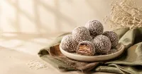 Illustration: coconut-dusted round wafer confections on an ivory plate, one cut open