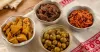 Several clean glass bowls of mango, olive, tamarind and chilli pickle