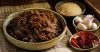 Spicy mixed Burmese-style pickle in a clear jar with a dry spoon