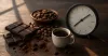 Dark chocolate squares beside cocoa beans, a small coffee cup and a clock