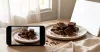 Phone photographing chocolate beside a window with a simple reflector