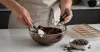Home baker checking glossy melted chocolate with a digital thermometer
