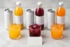 Unbranded cans, bottles and three fruit-coloured drinks arranged for a volume comparison
